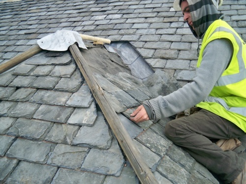 Hands repairing slate tiles